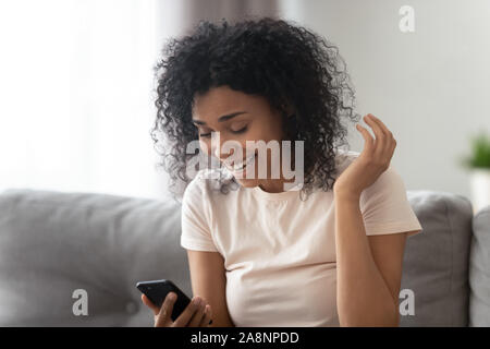 Überrascht African American Woman Reading unerwartet gute Nachrichten über das Telefon Stockfoto