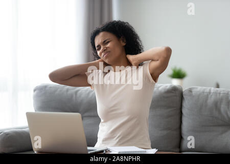 Unglücklich afrikanische amerikanische Frau Nacken zu massieren, leiden unter Schmerzen Stockfoto