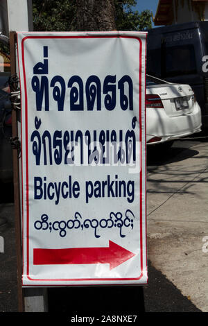 Mehrsprachige Zeichen für Fahrrad parken, in Thai, Englisch und Burma, im Wat Phra That Doi Kham, oder goldene Tempel, in der Nähe von Chiang Mai, Nordthailand Stockfoto