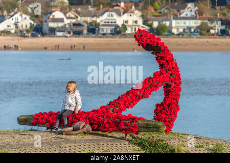 Appledore, North Devon, Großbritannien. Sonntag, 10. November 2019. UK Wetter. Sonnenschein und eine leichte Brise der Erinnerung Sonntag in North Devon. Das Wahrzeichen Anker in Appledore hat von der lokalen Gemeinschaft mit gestrickten Mohnblumen für Erinnerung Sonntag bedeckt worden. Terry Mathews/Alamy Leben Nachrichten. Stockfoto