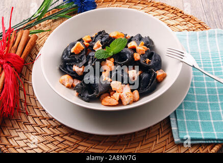 Schwarz Ravioli in Tintenfisch mit Lachs Stockfoto