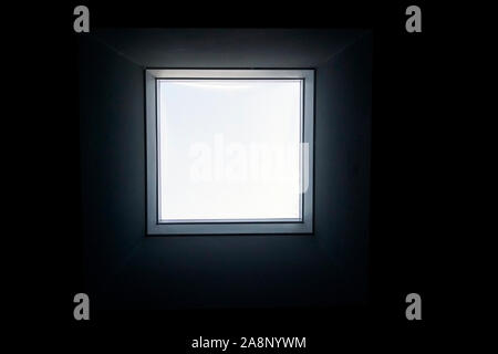 Close up Innenansicht eines echten Square einzigen Fenster mit dicker schwarze Wand, klar transparentes Glas, grau Aluminium Rahmen. Stockfoto
