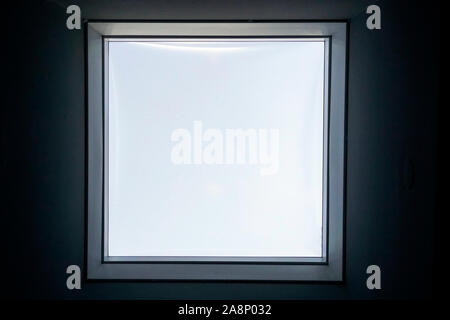 Close up Innenansicht eines echten Square einzigen Fenster mit dicker schwarze Wand, klar transparentes Glas, grau Aluminium Rahmen. Stockfoto