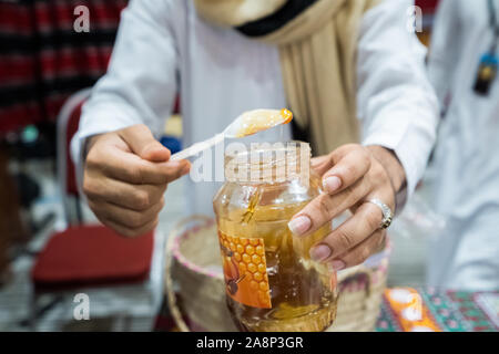 Ein Mann ist ein kleiner Löffel der Deluxe hochwertige jemenitischen Honig Stockfoto