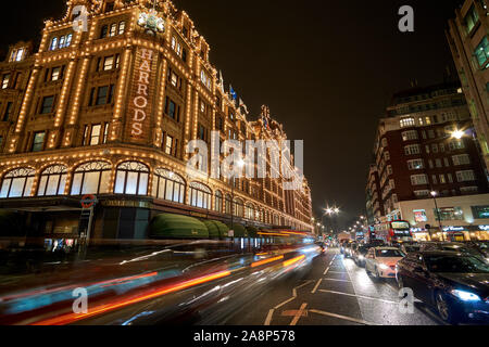 Außenansicht des Kaufhaus Harrods in London bei Nacht im Winter. Nacht Verkehr Straße Landschaft in einem typischen regnerischen Tag. Stockfoto