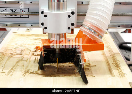 Fräsen einer Holzplatte. Die Bearbeitung von Holzplatten auf CNC-Fräsen koordinieren Holzbearbeitungsmaschinen. CNC-holzbearbeitungsmaschine. Stockfoto