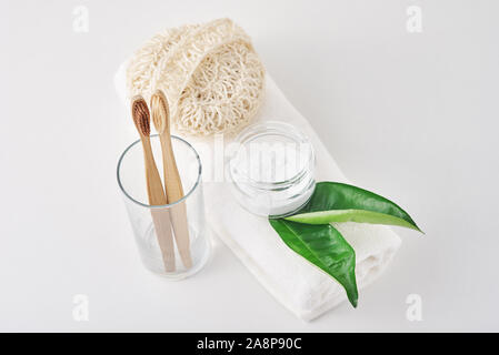 Holz Bambus Zahnbürsten in Glas, Natron und Handtuch auf weißem Hintergrund. Persönliche Hygiene Konzept Stockfoto