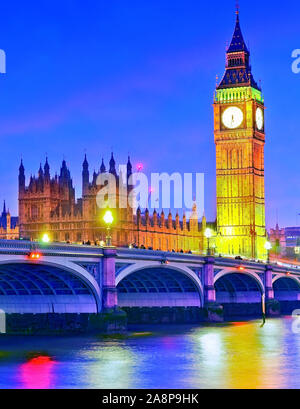 Blick auf die Parlamentsgebäude und die Westminster Bridge entlang der Themse in London bei Nacht. Stockfoto