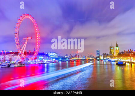 Blick auf die Häuser des Parlaments und London Eye entlang der Themse in London in der Nacht.