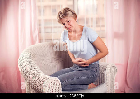 Frau fühlt sich starken Magen oder Schmerzen. Menschen, Gesundheitswesen und Medizin Konzept Stockfoto