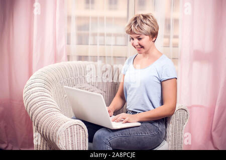 Frau arbeitet mit Laptop zu Hause. Leute, Internet- und Technologiekonzept Stockfoto