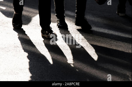 Verschwommene Schatten Silhouette von zwei Menschen zu Fuß auf Stadt Fußgängerzone in hoher Kontrast schwarz und weiß Stockfoto