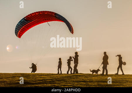 Bo-Peep Hill, Alciston, East Sussex, Großbritannien. November 2019. Auf den South Downs als Gleitschirmflieger sind viel los, Radfahrer und Wanderer nutzen das herrliche Wetter. . Stockfoto