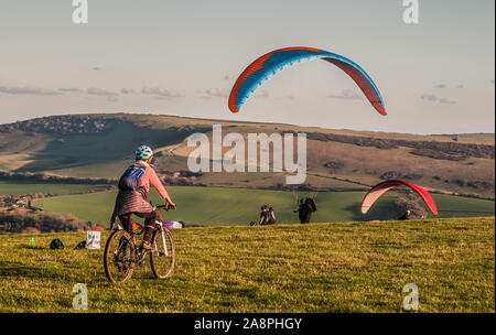 Bo-Peep Hill, Alciston, East Sussex, Großbritannien. November 2019. Auf den South Downs als Gleitschirmflieger sind viel los, Radfahrer und Wanderer nutzen das herrliche Wetter. . Stockfoto