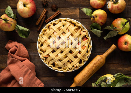 Apfelkuchen mit Gitter oben auf hölzernen Hintergrund, Table Top anzeigen. Rustikale american Apple Pie Stockfoto