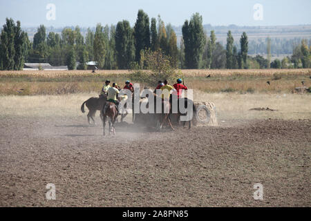 Reiter spielen traditionelle buzashi mit einer Ziege Karkasse in Kirgisistan Stockfoto