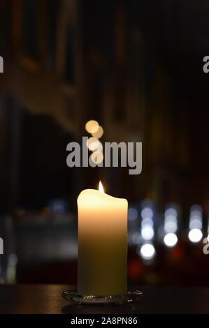 Eine Kerze mit schönen Bokeh und verschwommene Lichtreflexionen Stockfoto