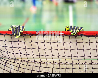 Torwart Handschuhe sind auf dem Lichtstrahl fussballtor Tor. Genaue sport Detail mit verschwommenen Hintergrund von Junior match Stockfoto