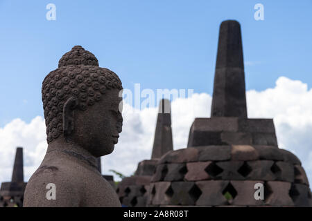 Ein Buddah in seinem Stupa von borobodur mit Blick auf das umliegende Land und wacht über die Vulkane. Einige von ihnen werden während der trockenen Jahreszeit geöffnet. Eine stun Stockfoto