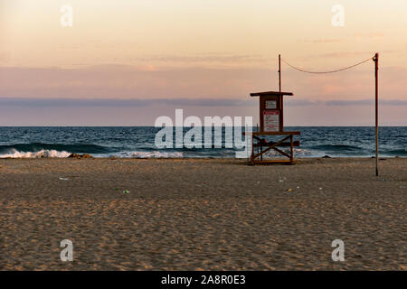 Newport, Kalifornien/USA - vom 18. Juli 2019: Ein roter Himmel bei Sonnenuntergang über dem Pazifischen Ozean und eine einsame Palme am Newport Beach in Kalifornien. Die Rettungsschwimmer Stockfoto