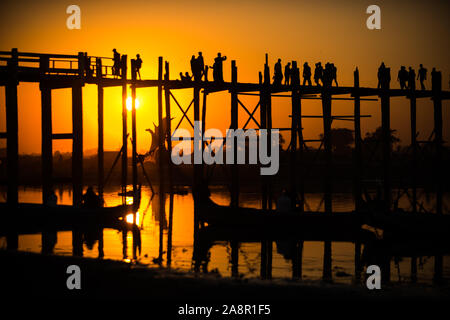 Silhouetten der Tourist in Boote und auf Brücke bewundern U-Bein Brücke über den Taungthaman See bei Sonnenuntergang in Amarapura. Mandalay, Myanmar Stockfoto