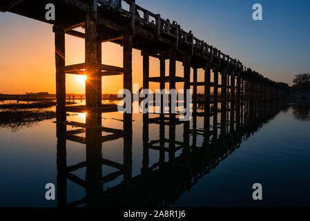 Silhouetten der Tourist auf Brücke bewundern U-Bein Brücke über den Taungthaman See bei Sonnenuntergang in Amarapura. Mandalay, Myanmar Stockfoto