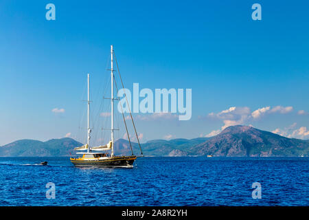 Segelboot mit einem Beiboot hinter an der Türkischen Riviera, Türkei gezogen Stockfoto