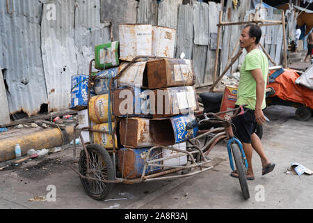Eine Last von leere Dose Behälter durch eine philippinische Mann, Geld, indem er sie in ein Metall Recycling center verdienen gesammelt. Stockfoto