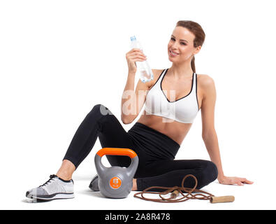 Frau mit Wasser in der Flasche nach dem Workout, isoliert auf weißem, Hydratation Stockfoto