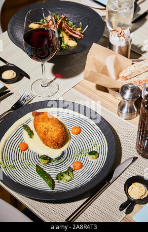 Huhn Kiew mit Kartoffelpüree auf Tisch mit Getränken im Restaurant serviert. Stockfoto