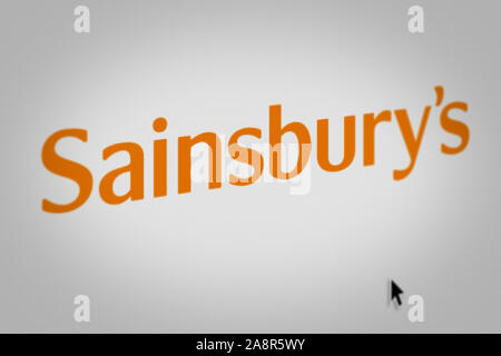 Logo der öffentlichen Unternehmen Sainsbury's auf einem Bildschirm in der Nähe angezeigt. Credit: PIXDUCE Stockfoto