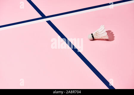 Federball zum Badminton auf rosa Oberfläche mit blauen und weißen Linien Stockfoto