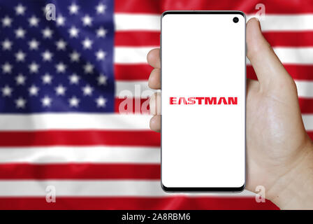 Logo der öffentlichen Unternehmen Eastman Chemical auf dem Smartphone angezeigt. Flagge der USA Hintergrund. Credit: PIXDUCE Stockfoto