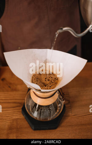 Teilweise mit Blick auf die Barista Vorbereitung Gießen-über Chemex Kaffeemaschine Kaffee Stockfoto