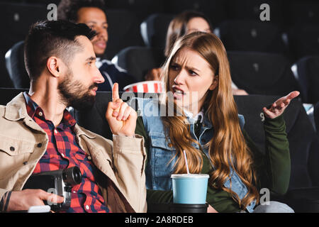 Selektiver Fokus des Menschen fotografieren mit Digitalkamera und zeigen shh Geste, die wütende Frau im Kino. Stockfoto
