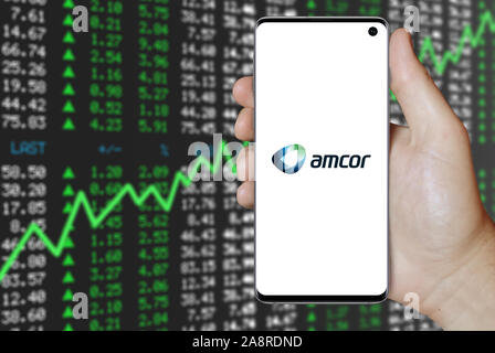 Logo der öffentlichen Amcor plc angezeigt auf einem Smartphone. Positive Börse Hintergrund. Credit: PIXDUCE Stockfoto