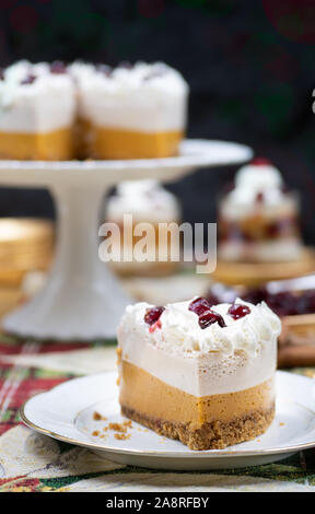 Weihnachten Kürbis und Cranberry Mousse auf Kuchen stand, auf einem festlich gedeckten Tisch Stockfoto