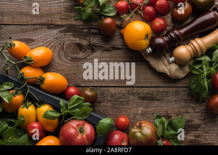 Blick von oben auf die Tomaten und Spinat in Feld in der Nähe von Pfeffer und Salz Mühle Mühle am Stück Stoff auf Holz- Oberfläche Stockfoto