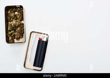 Blick von oben auf die Metallbox mit Marihuana Knospen und Rolling Paper in der Nähe der Heller Stockfoto