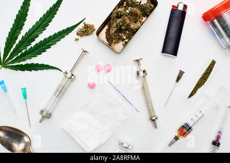 Blick von oben auf die Knospen, Cannabis leaf Marihuana, Heroin, Pillen und Spritzen auf weißem Hintergrund Stockfoto