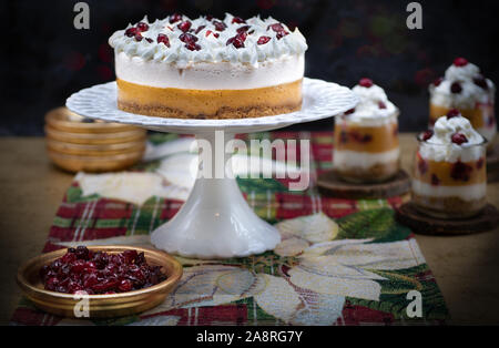 Weihnachten Kürbis und Cranberry Mousse auf Kuchen stand, auf einem festlich gedeckten Tisch Stockfoto