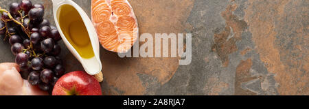 Panorama-aufnahme des rohen Lachs filet Steak, Hühnchen, Traube, Apfel, Olivenöl auf Marmor Oberfläche mit Kopie Raum Stockfoto