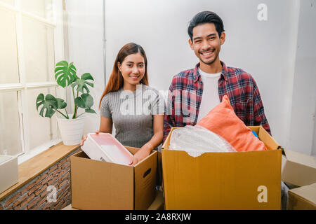 Asiatisches junges Paar mit großen Kartons für den Umzug in neues Haus, Umzug und Wohnungssuche Konzept Stockfoto