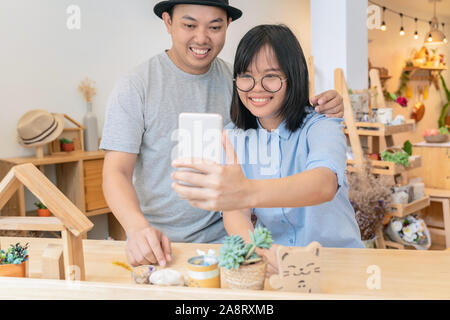 Asiatisches Junges Paar die selfie mit Glück im modernen Café oder Arbeitsplatz oder Co-working space oder moderne Büro-, Lifestyle- und Leis Stockfoto