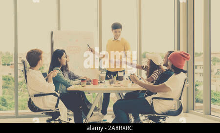 Asiatische junge Manager Präsentation der kreativen Ideen vor der Gruppe der Asiatischen und multiethnische Geschäftsleute mit lässiger Anzug in Aktion in der m Stockfoto