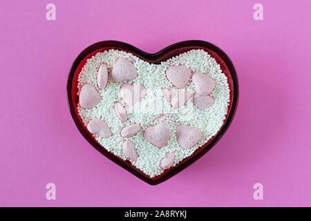Valentine Candy Herzen und Streusel in eine Herzförmige Schale. Stockfoto