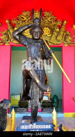 Ein Affe König Statue mit einem hellen roten Wand behine Es und Gold der chinesischen Schrift. Stockfoto