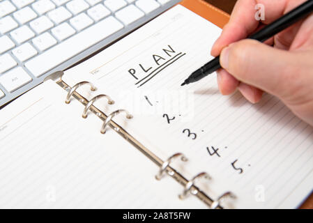 Nahaufnahme der Hand ein Geschäftsmann schreiben Plan und im Tagebuch. Stockfoto