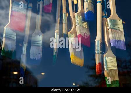 In der Nähe der bunten Farben und Pinsel als Schaufensterdekoration auf einem dunklen Hintergrund. Stockfoto