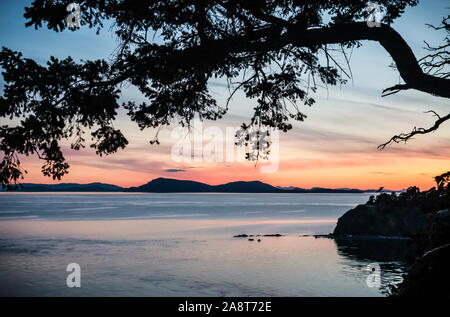 Ein Blick aus der Nähe von Fox auf sucia Island bei Sonnenuntergang in den San Juan Inseln, Washington, USA Bucht. Die fernen Inseln sind meist in BC Kanada und sind die Stockfoto